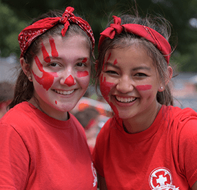 two girls dressed in red with face paint