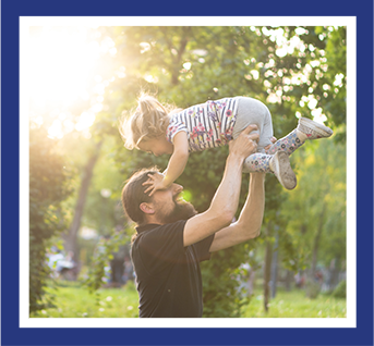 a dad playing with his daughter in a park