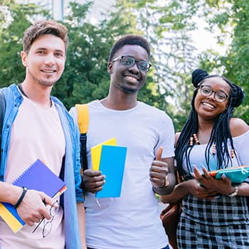 three students smiling at the camera