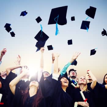 graduates throwing caps into the air