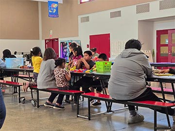 Students sitting at long tables for an activity