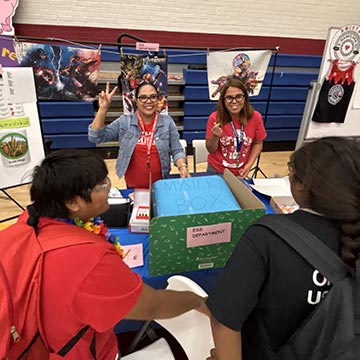 Staff members running a stall in the gym for students