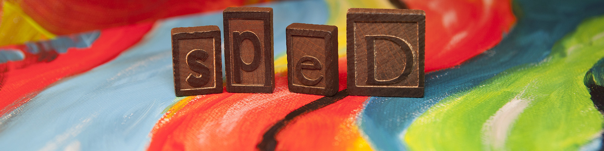 wooden tiles that read sped on a watercolor