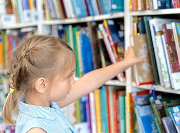 student looking at books on shelves