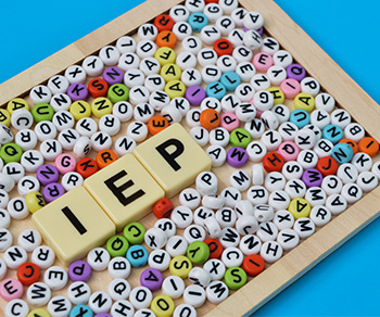 lettered pony beads in a frame with wooden tiles in the middle that spell IEP