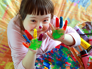 A student showing their hands after fingerpainting