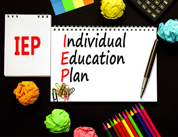 school supplies around notepads that read IEP Individual Education Plan