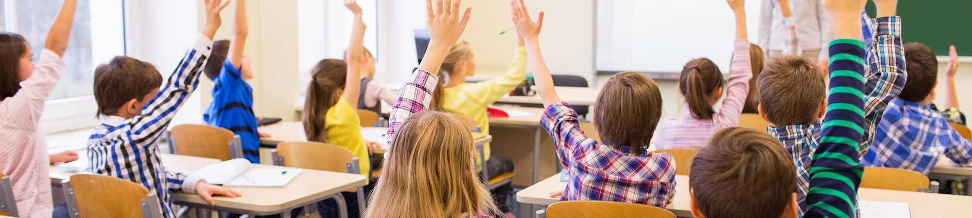 students raising their hands in class