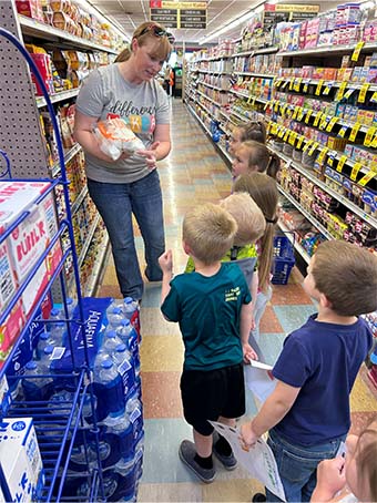 parent helping students pick things at the grocery store