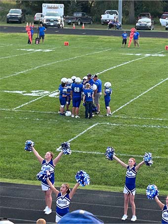 Football team huddled on field