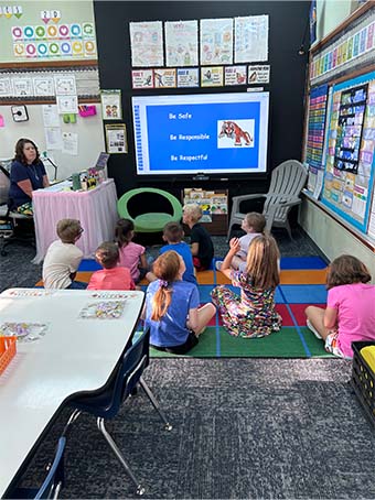 students sitting on a rug learning