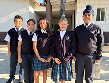 Group of five happy students outside