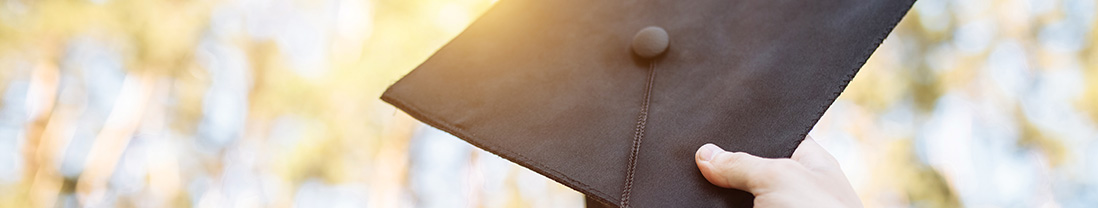 Graduation cap lifted up to the sky