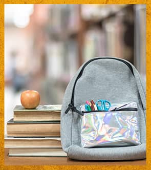Backpack, books, and an apple on a table in the library