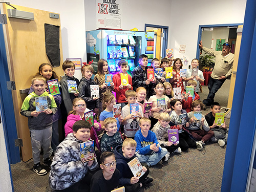 Group of happy students posing for a picture with their new books