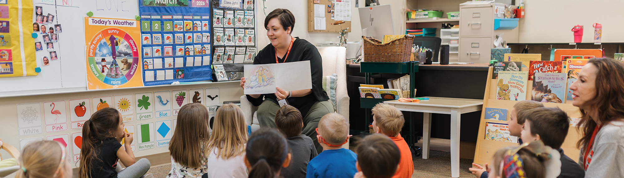 Teacher reading a book to pre-kindergarten children