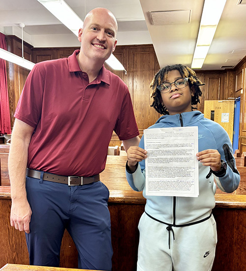 Teacher and student posing for a picture with Project Soapbox competition project