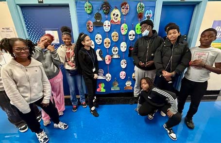 Students in front of Dia de los Muertos masks they made