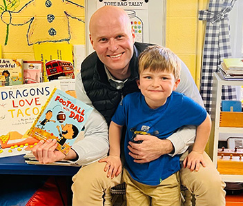 Adult holding a students and two books