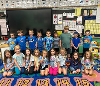 Elementary students posing for a picture in the classroom