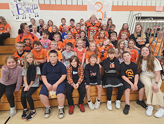Classmates sitting in the gym for a group photo