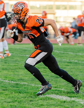 Athlete running down the field during a football game