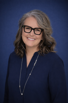 A headshot of Kerry Turner with a blue background