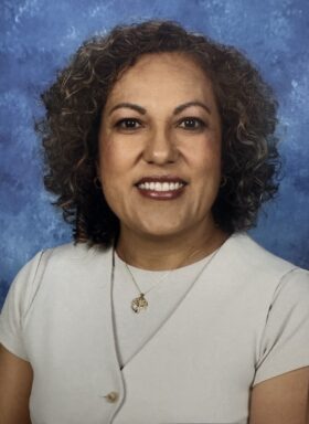 A picture of LUcy Garcia with a blue background.