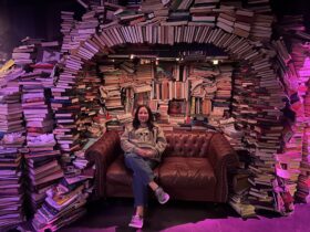 A zoomed out photo of Paloma Fix with an arch of books in the background.