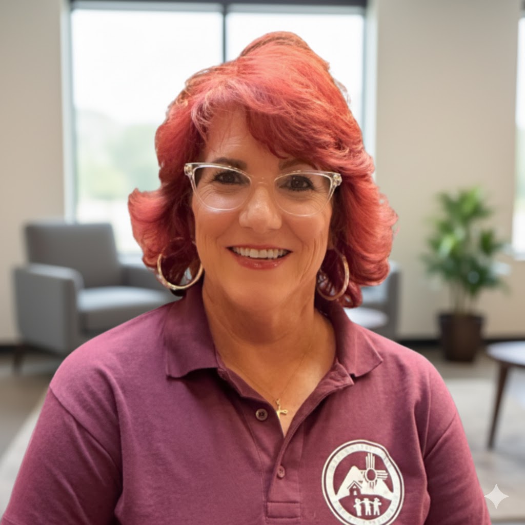 A headshot shows Valerie Brea. With reddish-orange, shoulder-length hair. She is wearing clear-framed glasses and smiling broadly. She has a dark red collared shirt. The background is a gradient of dark gray to light gray.