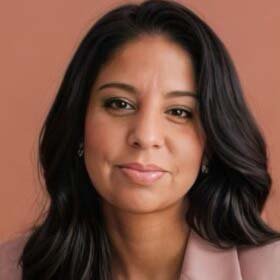 A headshot of Maria Miller, a Latina woman with long dark brown hair and brown eyes. She is wearing a light pink blazer and a silver necklace with a small gold bead. She has a subtle smile and is looking directly at the camera.