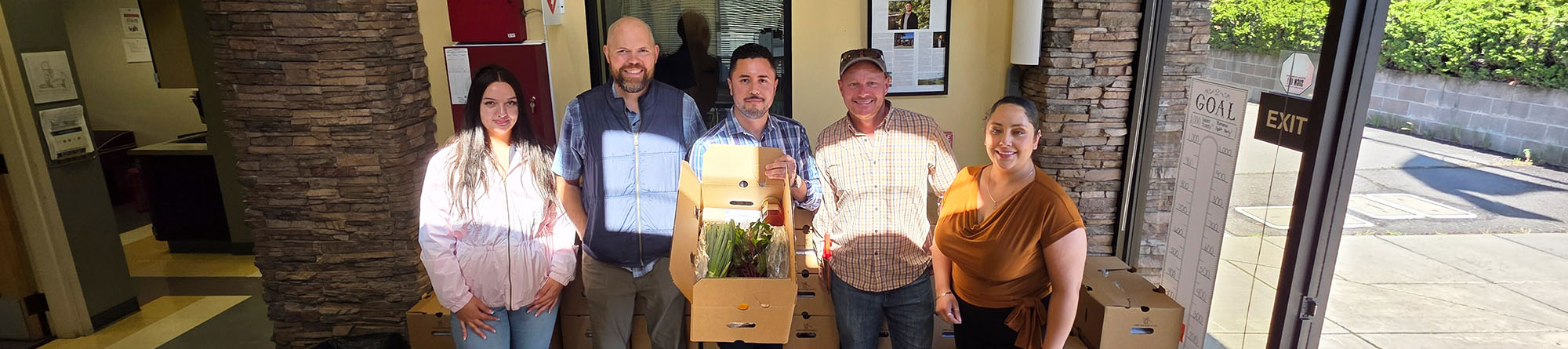 Group of Howell Mountain representatives with Long Meadows Ranch holding a big box of fresh produce