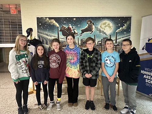 Sixth grade students smiling for the camera as they visit a board meeting