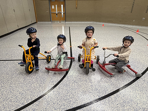 Happy Pre–K Students enjoying a bike activity