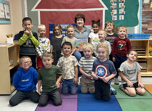 Pre-K students posing for a picture with their guest reader