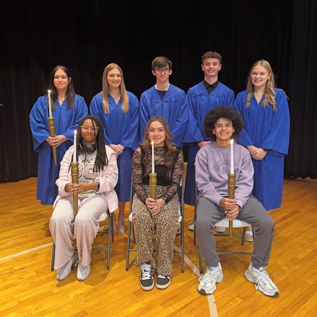 NHS Inductees on a stage posing for a picture