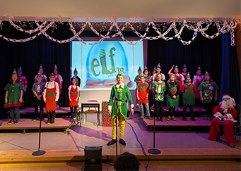 Elementary students on stage performing Elf Jr.