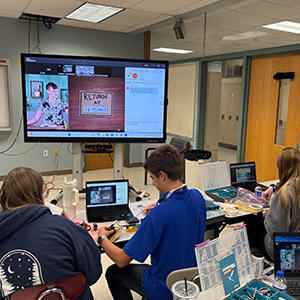 Students watching a presentation and working on projects together