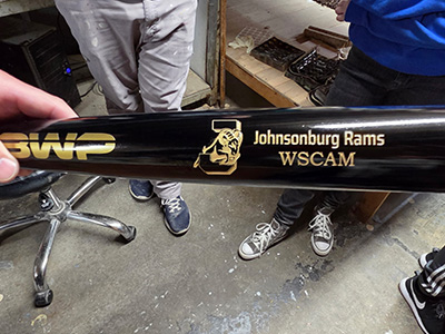 A baseball bat with the school logo and BWP Johnsonburg Rams WSCAM on it
