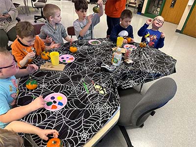 students painting pumpkins