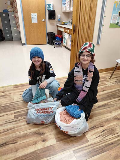 Two students with hats in bags