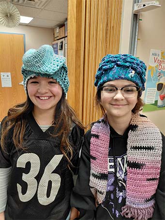 sidebargraphic_sucessfulbeginnings1 Two students wearing handmade hats and scarves