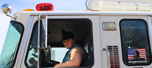 A student in the passenger seat of an emergency vehicle