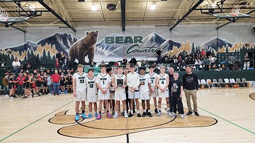 Boys basketball team on the court holding an award