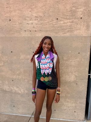 smiling female student athlete with 4 medals around her neck