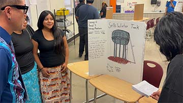 Student looking at project board