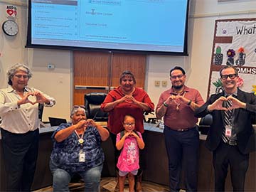 Student with staff making hearts with hands