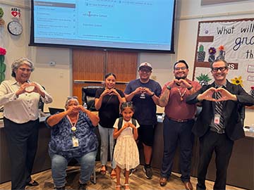 Student with staff making hearts with hands
