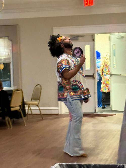 One male teacher dressed as a hippie dancing