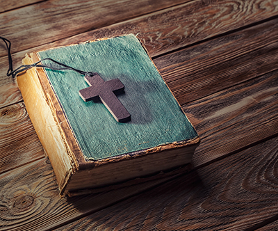 Christian cross on Bible on wood table